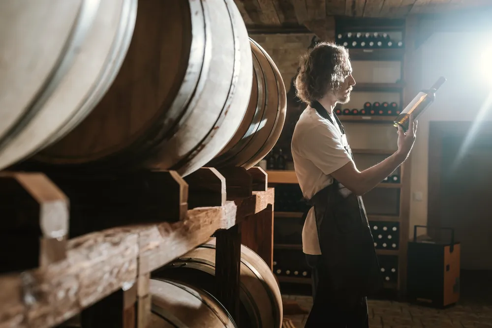 Una donna odora e assaggia un vino per determinarne la qualità segnando gli appunti in un foglio