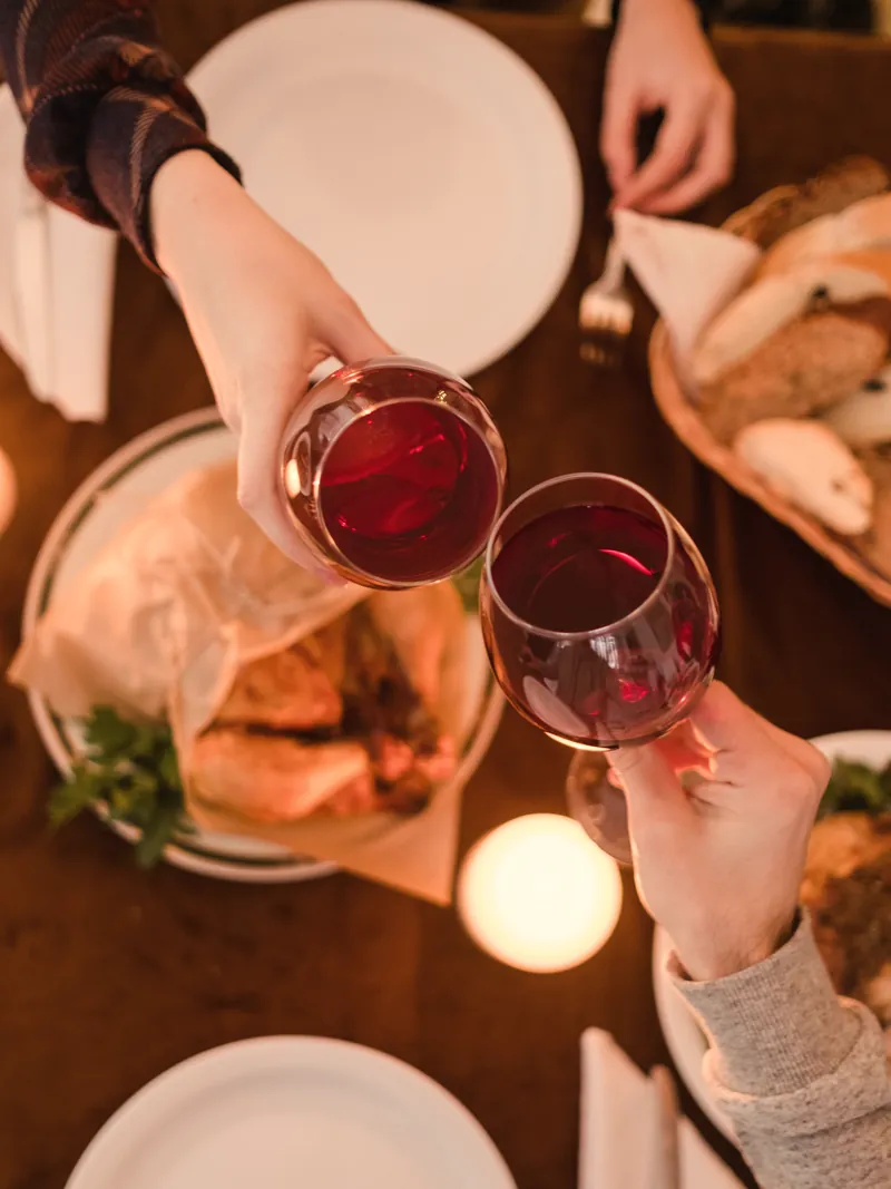 Un brindisi con due calici di vino rosso a tavola